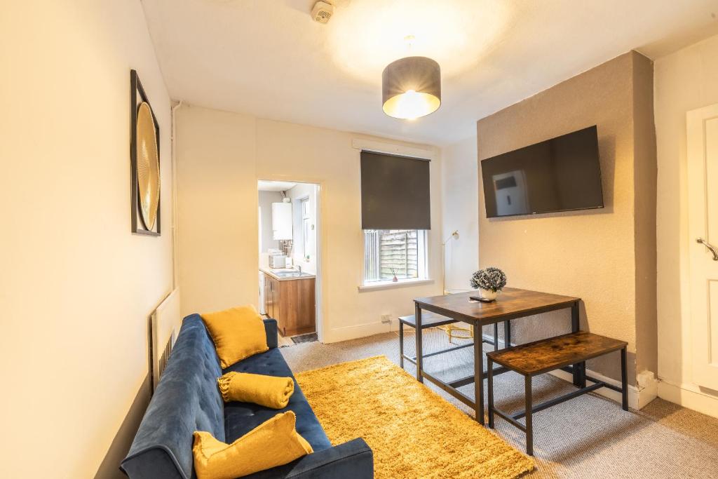 ein Wohnzimmer mit einem blauen Sofa und einem Tisch in der Unterkunft Westminster House - Contractors/Families in Birmingham
