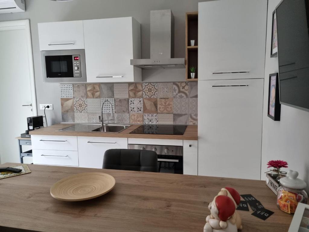 a kitchen with white cabinets and a wooden table at Cà Fiamma in Casale Monferrato