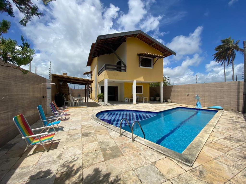 une villa avec une piscine en face d'une maison dans l'établissement Casa de Praia beira-mar, à Lucena