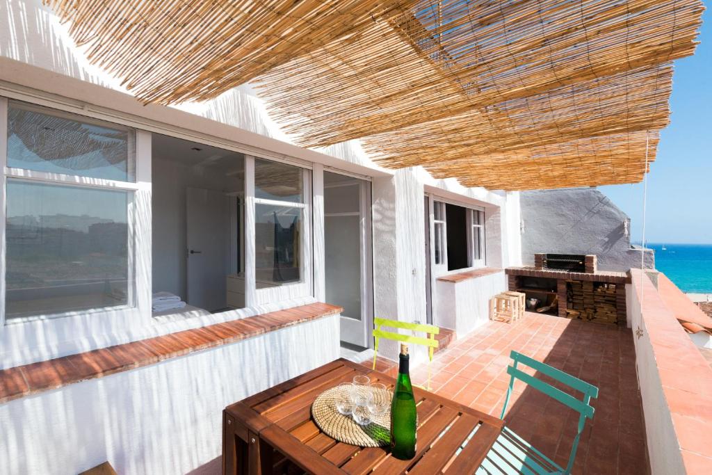 een patio met een tafel en een fles wijn bij Apartamento Corall in Blanes