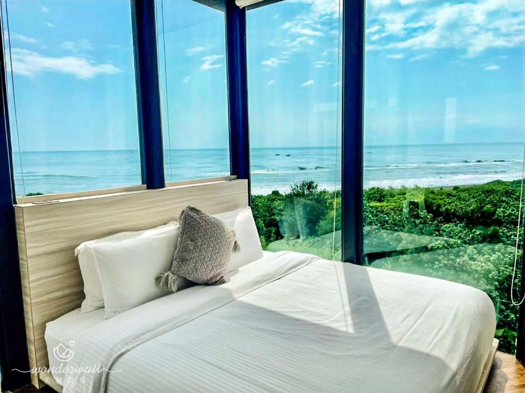 a bedroom with a bed with a view of the ocean at Wonderwall in Wujie