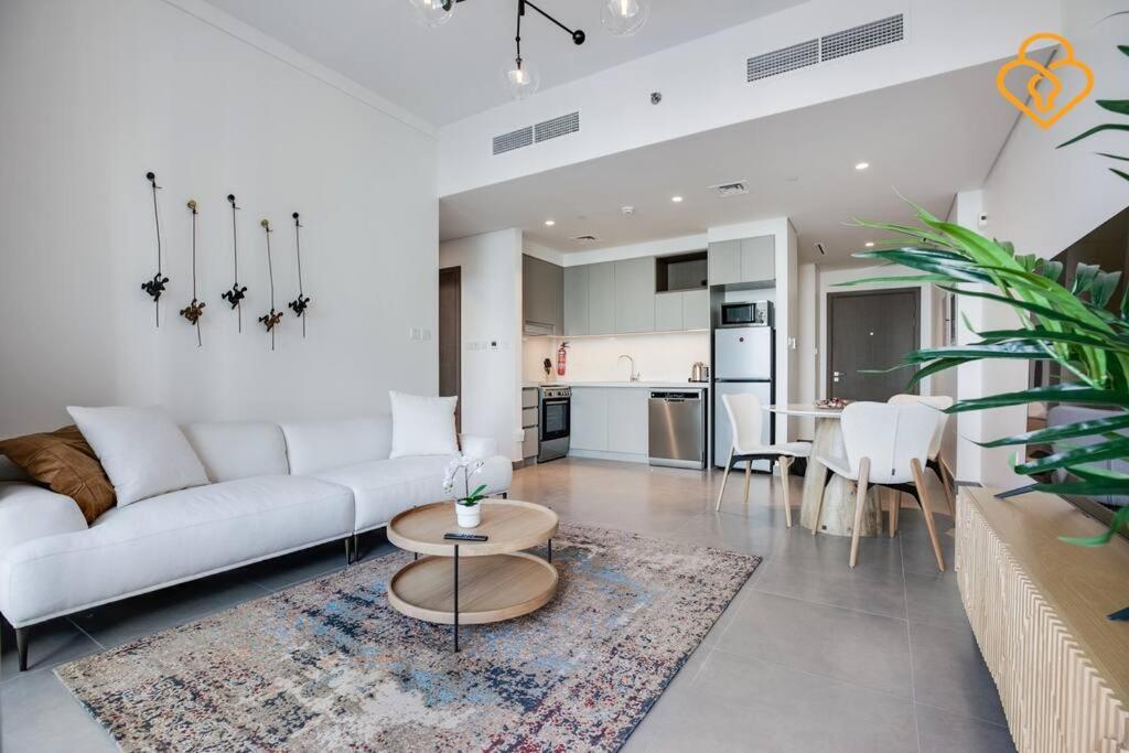uma sala de estar com um sofá branco e uma cozinha em Keysplease Modern Luxury 1 BR Creek Harbour 2808 no Dubai