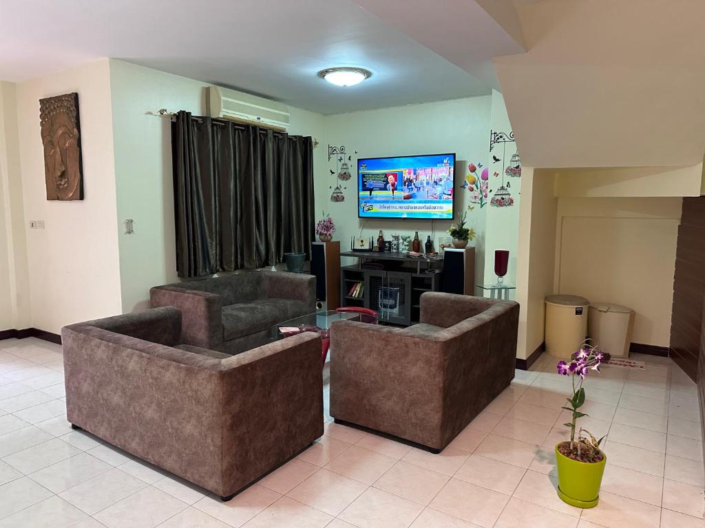 sala de estar con 2 sofás y TV en Hideaway House Patong, en Patong Beach