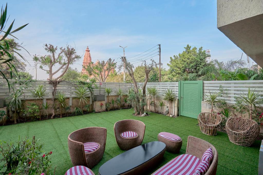 a garden with chairs and a fence and a fence at Designer Baron Palace 4BR Garden Duplex in Cairo