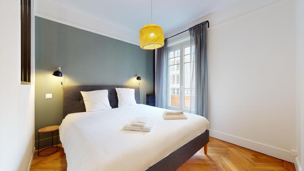 Un dormitorio con una gran cama blanca y una ventana en Beautiful modern apartment with balcony in Geneva en Ginebra