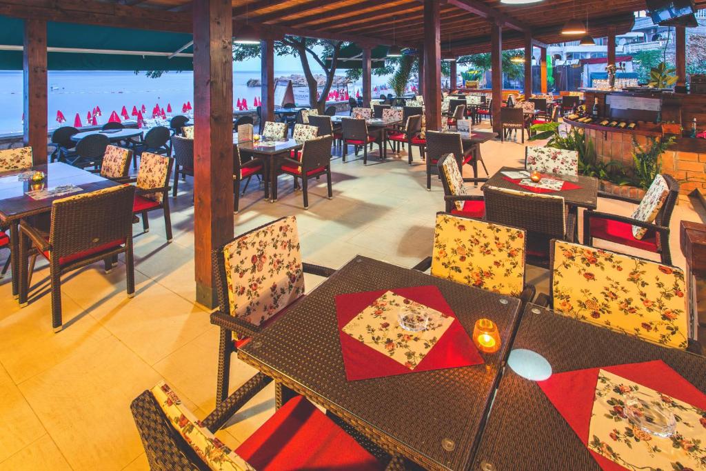 a restaurant with tables and chairs with a view of the ocean at Apartments Deus in Dobra Voda