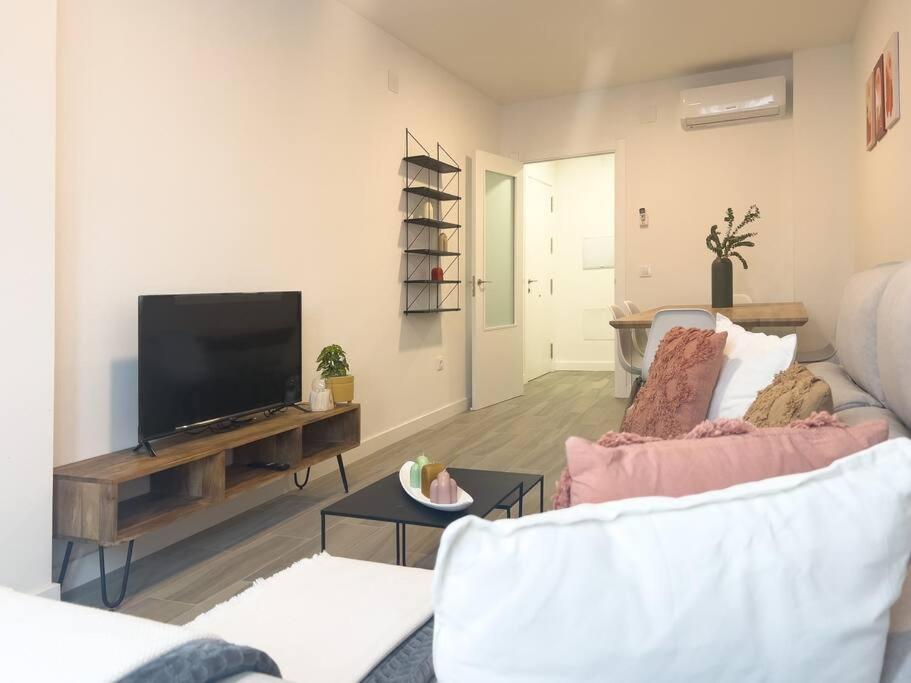 a living room with a couch and a tv at Apartamentos Gredos 002 in Jaraiz de la Vera
