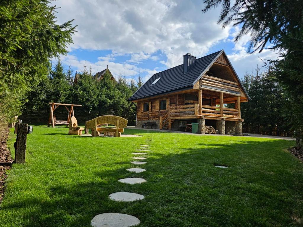 a log cabin with a path in the grass at Domek LUNA in Olchowiec