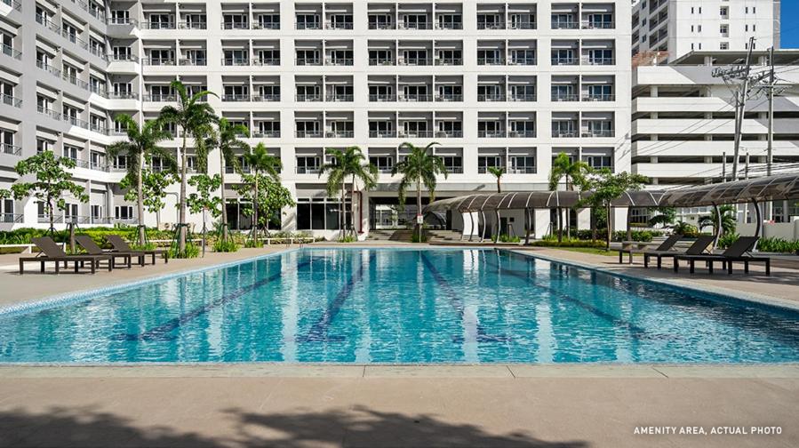 a large swimming pool in front of a building at Grace Residences Elevate Escapes in Manila