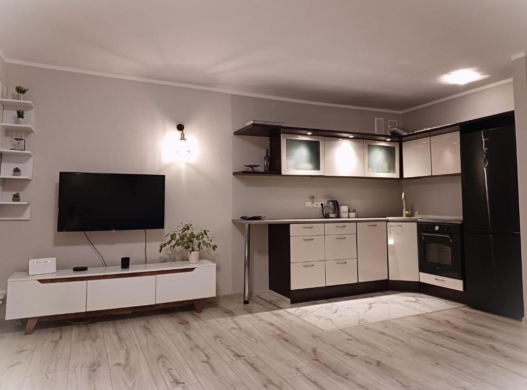 una cucina con armadi bianchi e una TV a schermo piatto di MY apartement, 3 tuba, privaatne sissekäik a Tartu