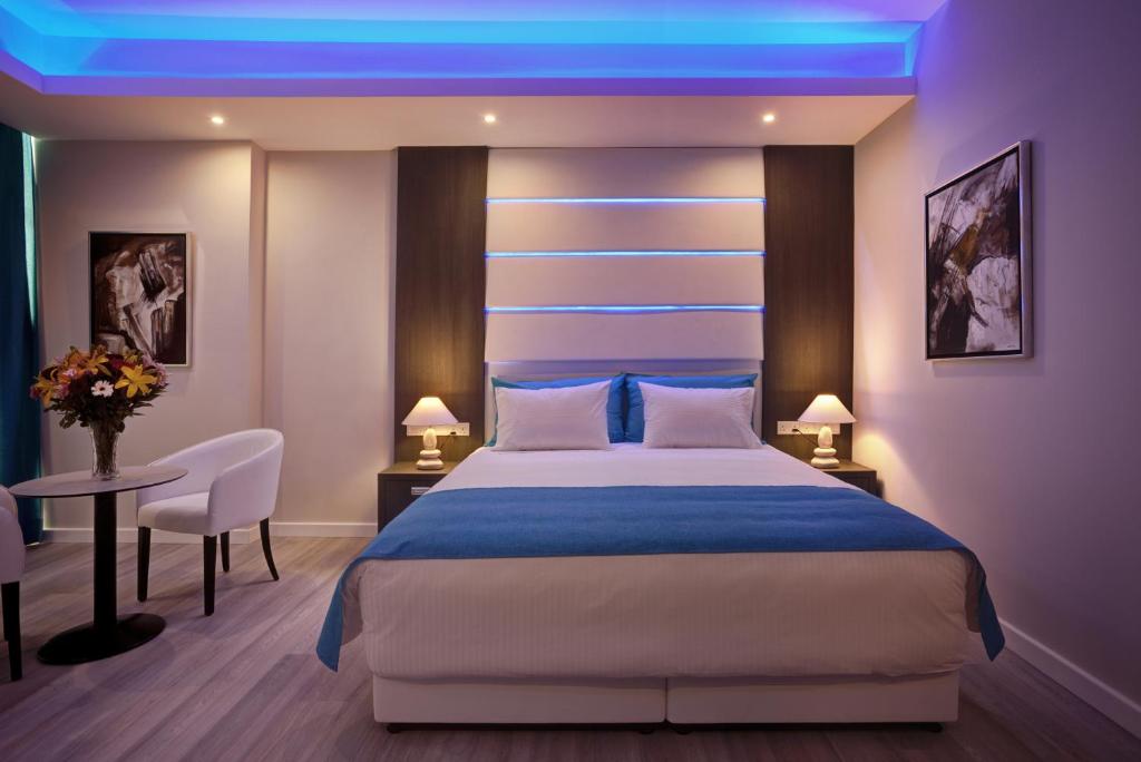 a bedroom with a large bed with a blue lighting at The Josephine Boutique Hotel in Larnaka