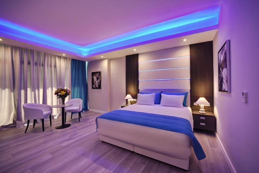a bedroom with a large bed and a table with chairs at The Josephine Boutique Hotel in Larnaca
