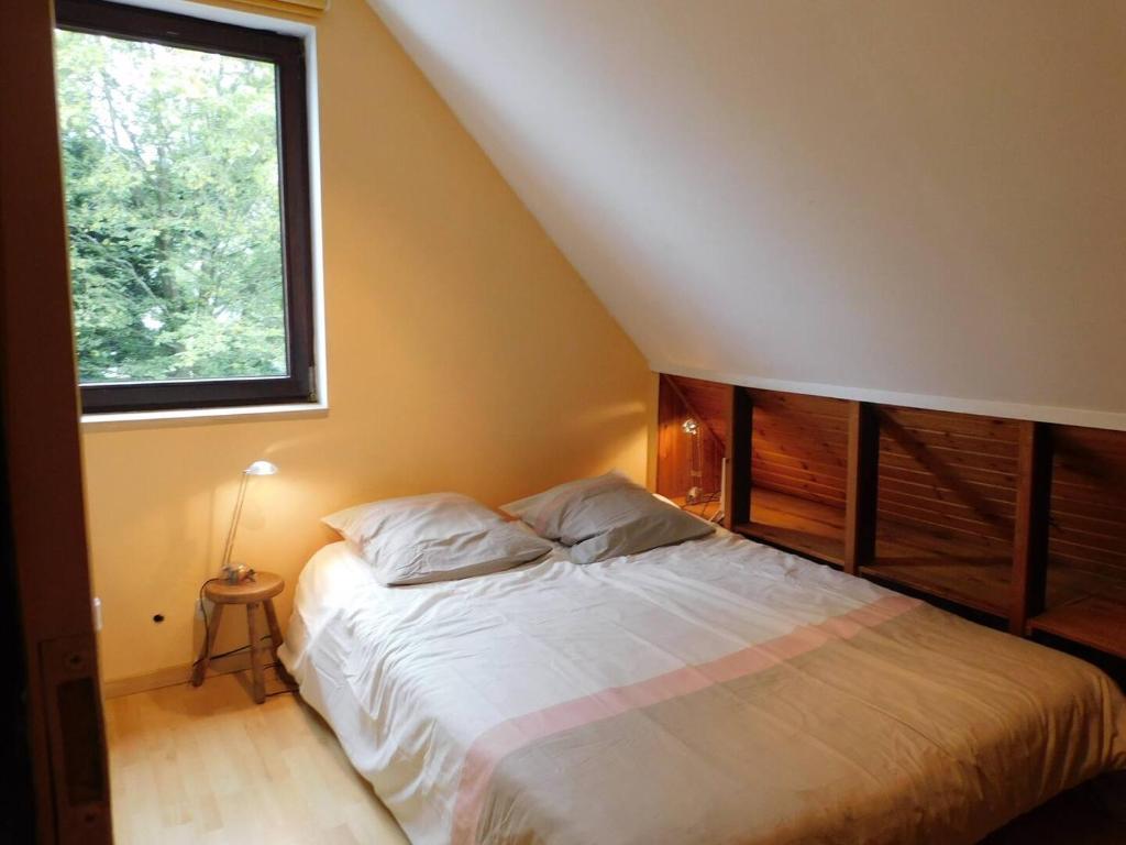 a bedroom with a bed with a large window at Emon nos-ôtes in Namur