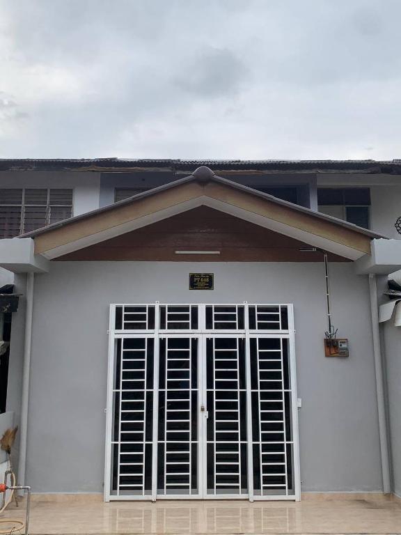 a white garage door with a sign on it at Zahra Homestay in Rantau Panjang