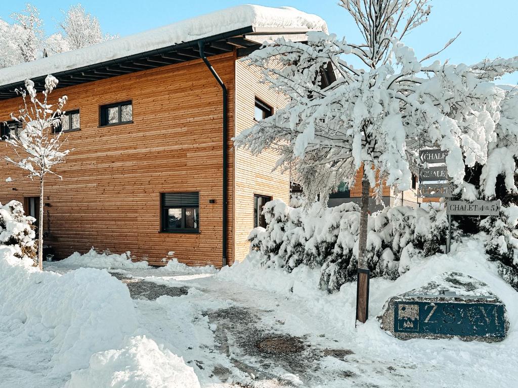a building covered in snow with a street sign at ZSAM Chalets mit Sauna und Hottub in Garmisch-Partenkirchen