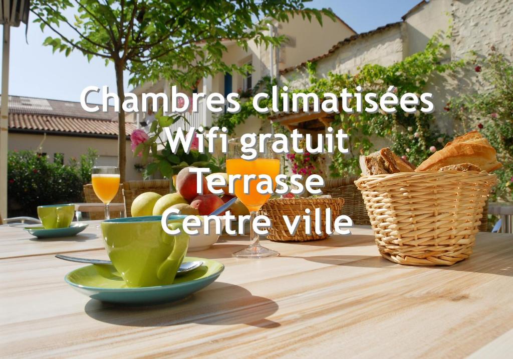 a table with a cup of coffee and a basket of bread at Le Cheval Blanc, Cognac Centre in Cognac