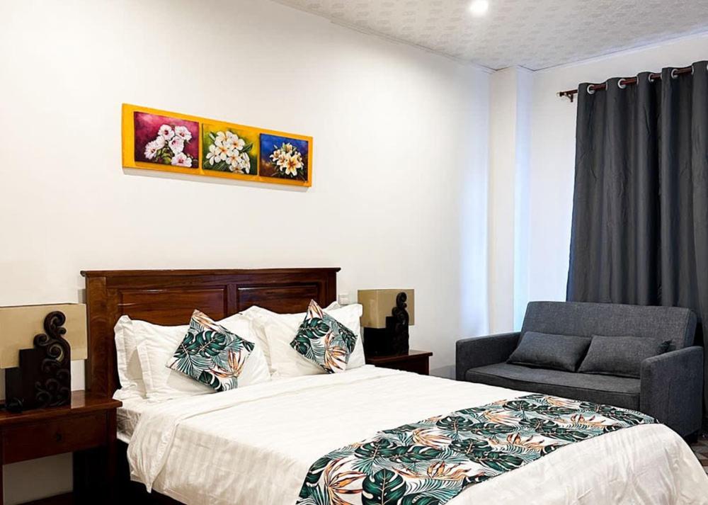 1 dormitorio con 1 cama y 1 silla en Crown Royale Hotel & Lounge, en Port Vila