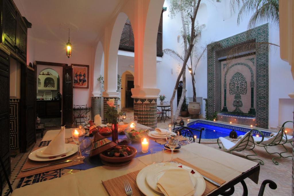 馬拉喀什的住宿－里亞德阿爾瑪姆辛旅館，一间带桌子和游泳池的用餐室
