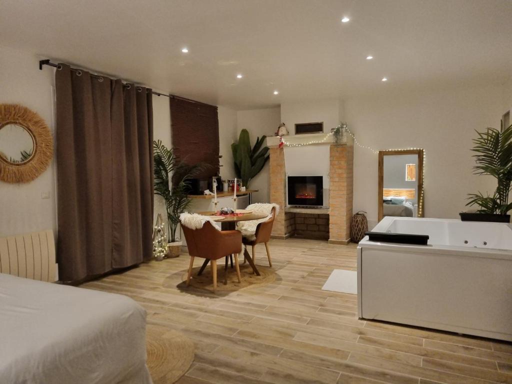 uma sala de estar com uma cama e uma sala de jantar em Levasion romantique loft jacuzzi et jardin privatif à 20 minutes de Paris et 10 minutes Stade de France Wifi Netflix em Saint-Prix