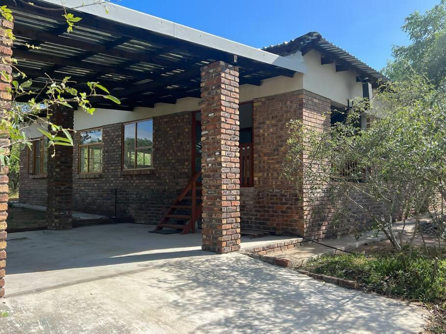 une maison en briques avec un toit et un escalier dans l'établissement Bushveld Getaway, à Marloth Park