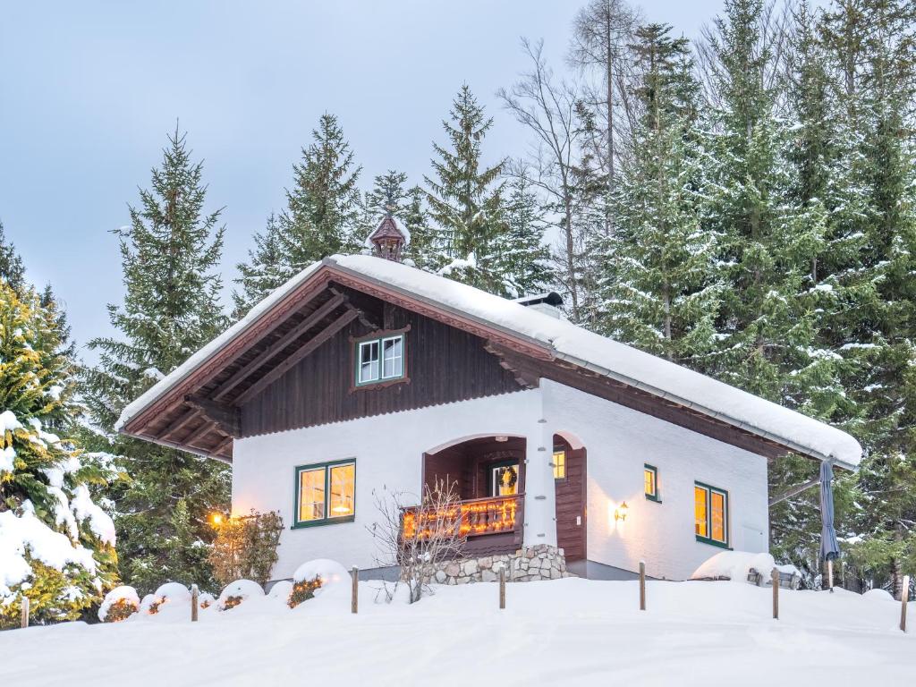 una piccola casa nella neve con gli alberi di Strickerl a Bad Goisern