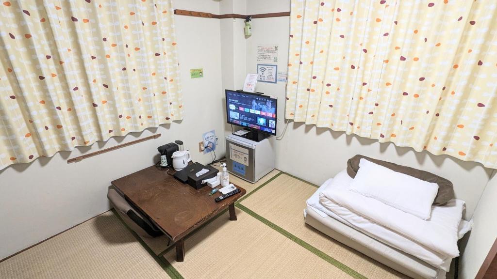 OYO Ryokan Hamanako no Yado Kosai - Vacation STAY 38804v في Kosai: غرفة معيشة مع أريكة وتلفزيون
