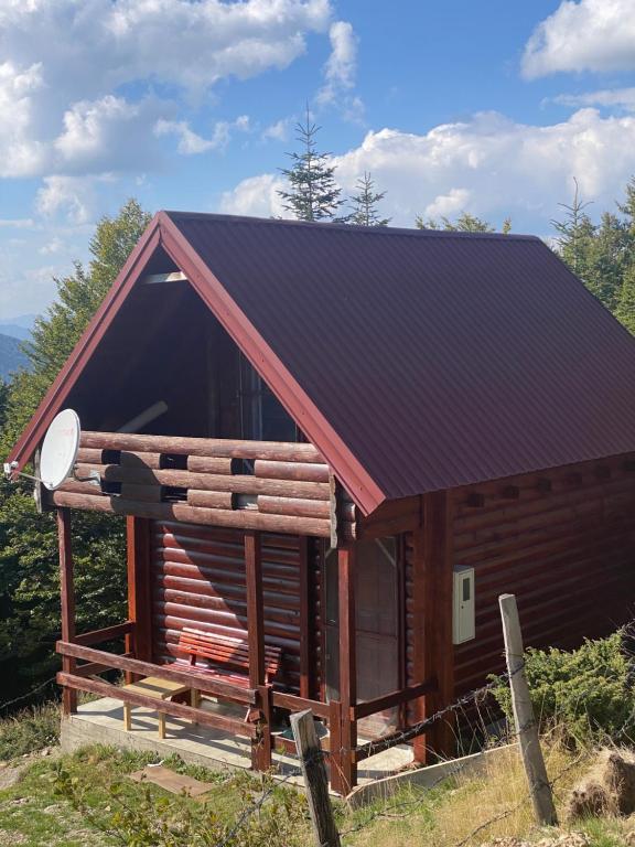 Cabaña de madera pequeña con techo negro en Mountine cottage Hajdi Komovi, en Podgorica