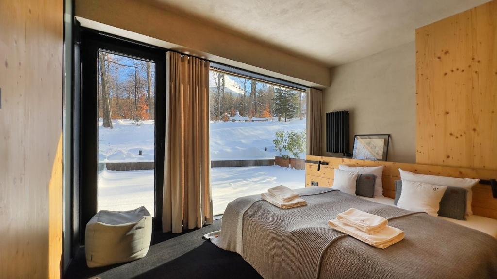 een slaapkamer met een bed en een groot raam bij Wilcza For Rest in Karpacz