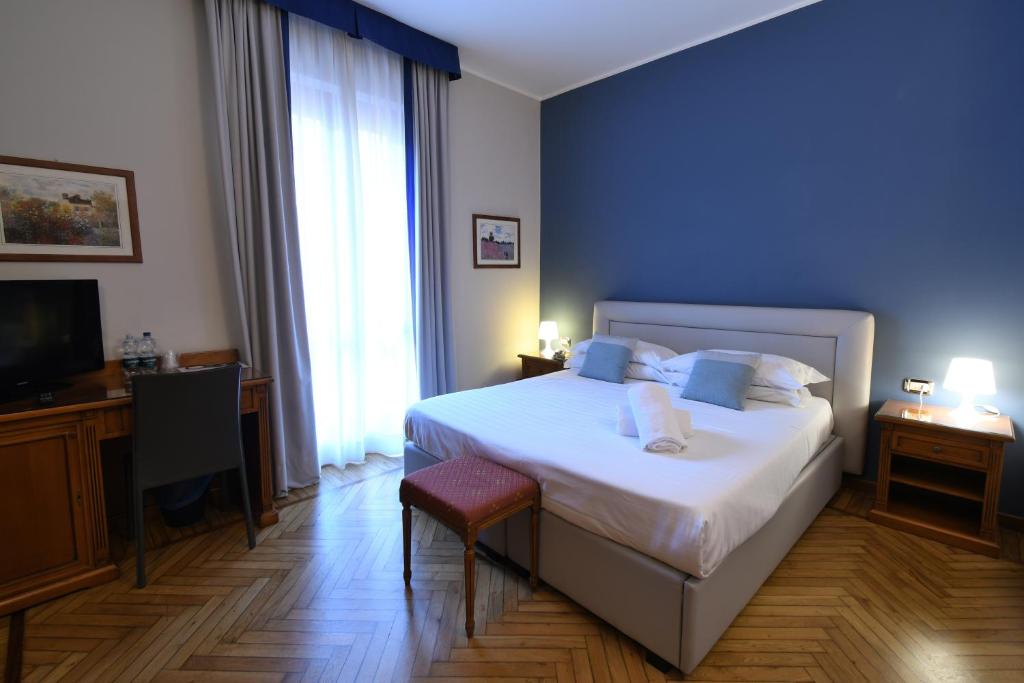 a bedroom with a large bed and a television at Hotel Cavour in Rapallo