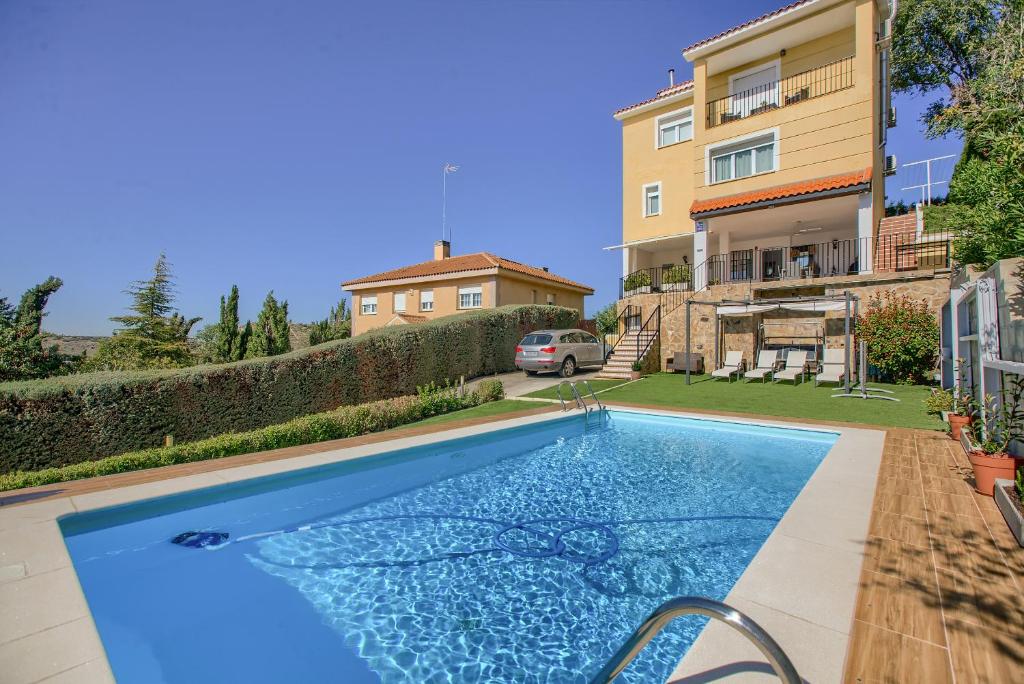 - une piscine en face d'une maison dans l'établissement Chalet con Piscina en Aranjuez, à Aranjuez