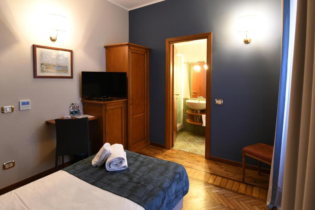 a hotel room with a bed and a bathroom at Hotel Cavour in Rapallo