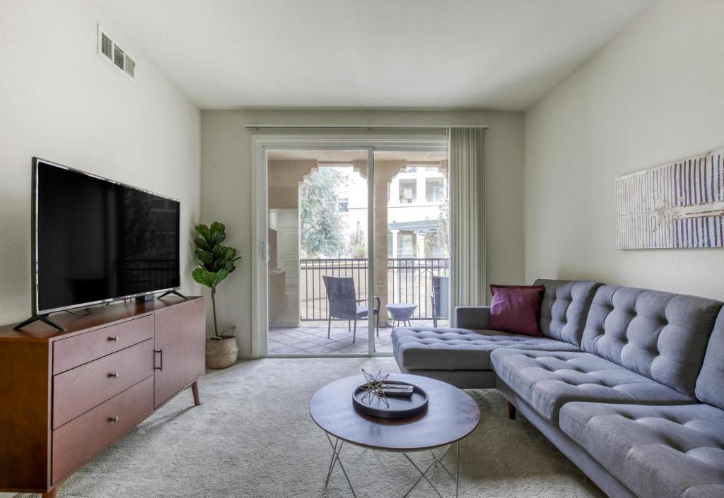 a living room with a couch and a tv at Santa Clara 2br w pool balcony elevator gym SFO-1587 in Santa Clara