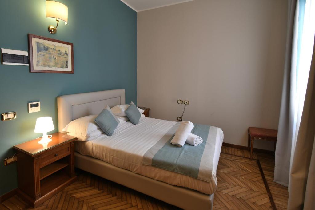 a bedroom with a large bed with blue walls at Hotel Cavour in Rapallo