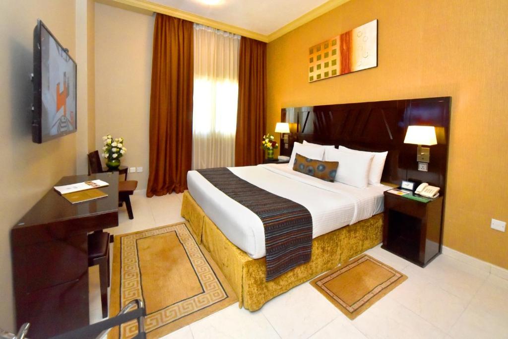 a hotel room with a large bed and a television at Emirates Stars Hotel Apartments Dubai in Dubai