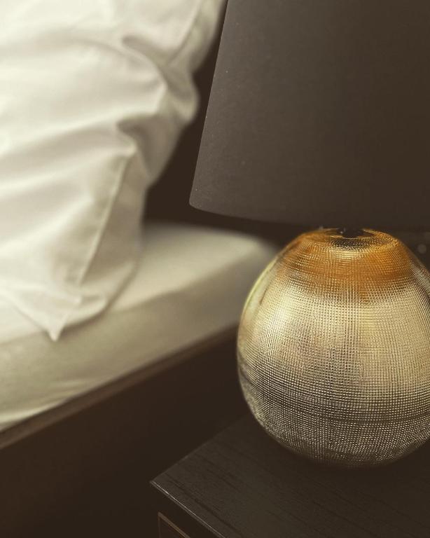 a lamp sitting on a table next to a bed at Apartmány Siesta in Poľný Kesov