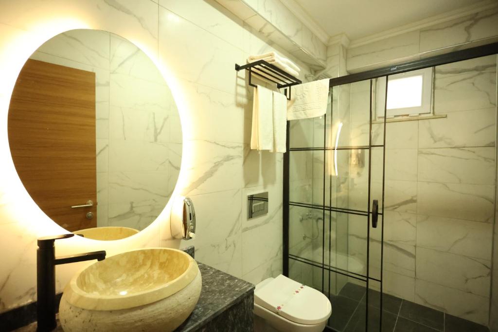 a bathroom with a sink and a toilet and a mirror at Asmali Hotel in Istanbul