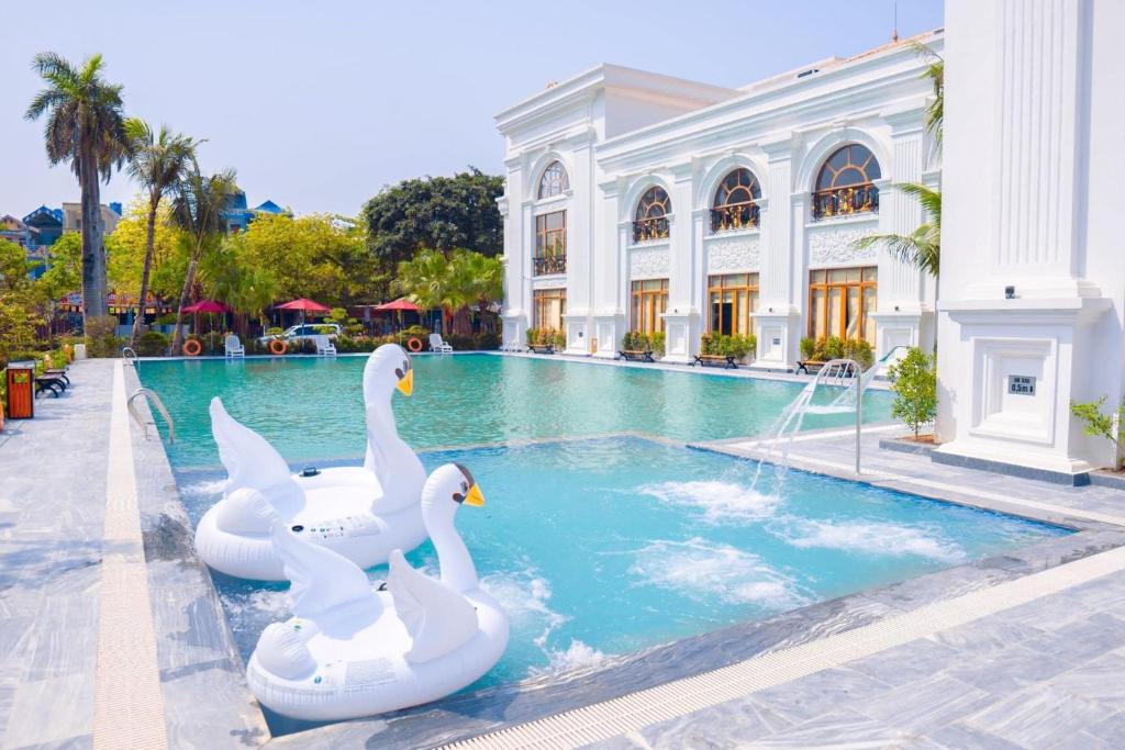 three swans in a swimming pool in a building at Hoa Nam Hotel 