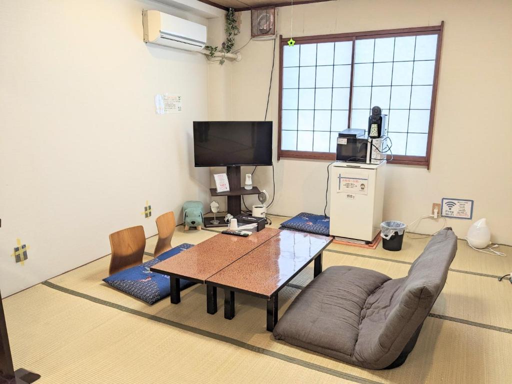 a living room with a table and a couch and a tv at OYO Ryokan Hamanako no Yado Kosai - Vacation STAY 38825v in Kosai