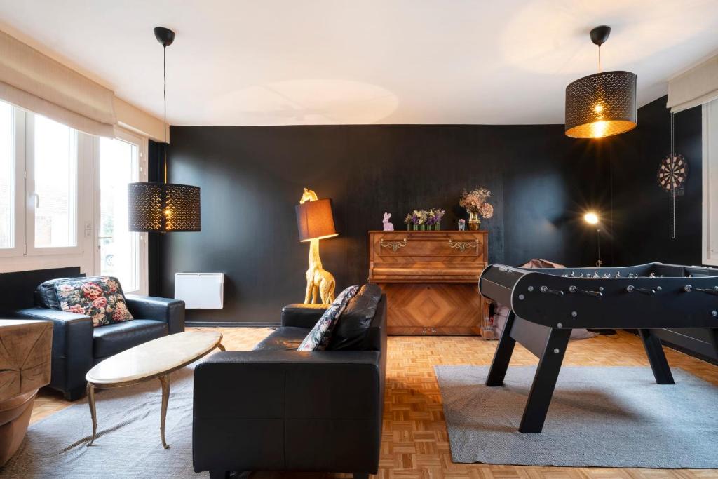een woonkamer met een zwarte muur en een piano bij La Messine in Metz