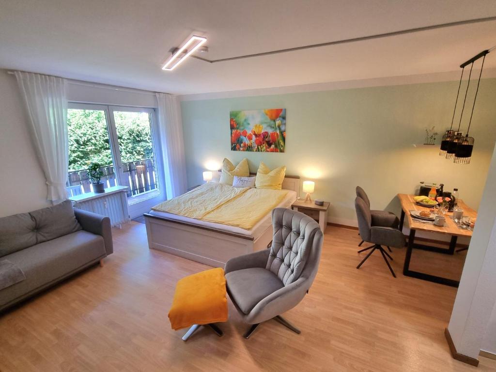 a bedroom with a bed and two chairs and a table at Auszeit Ferienwohnung in Bad Bevensen
