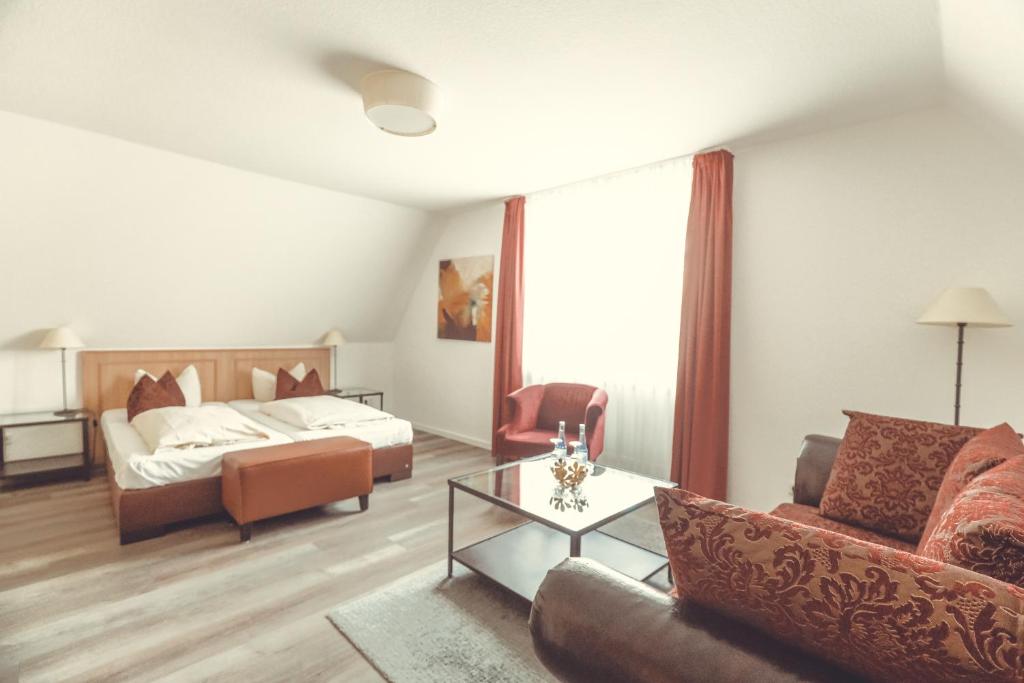 Hotel- Restaurant Einklang في Mettingen: غرفة معيشة مع سرير وأريكة