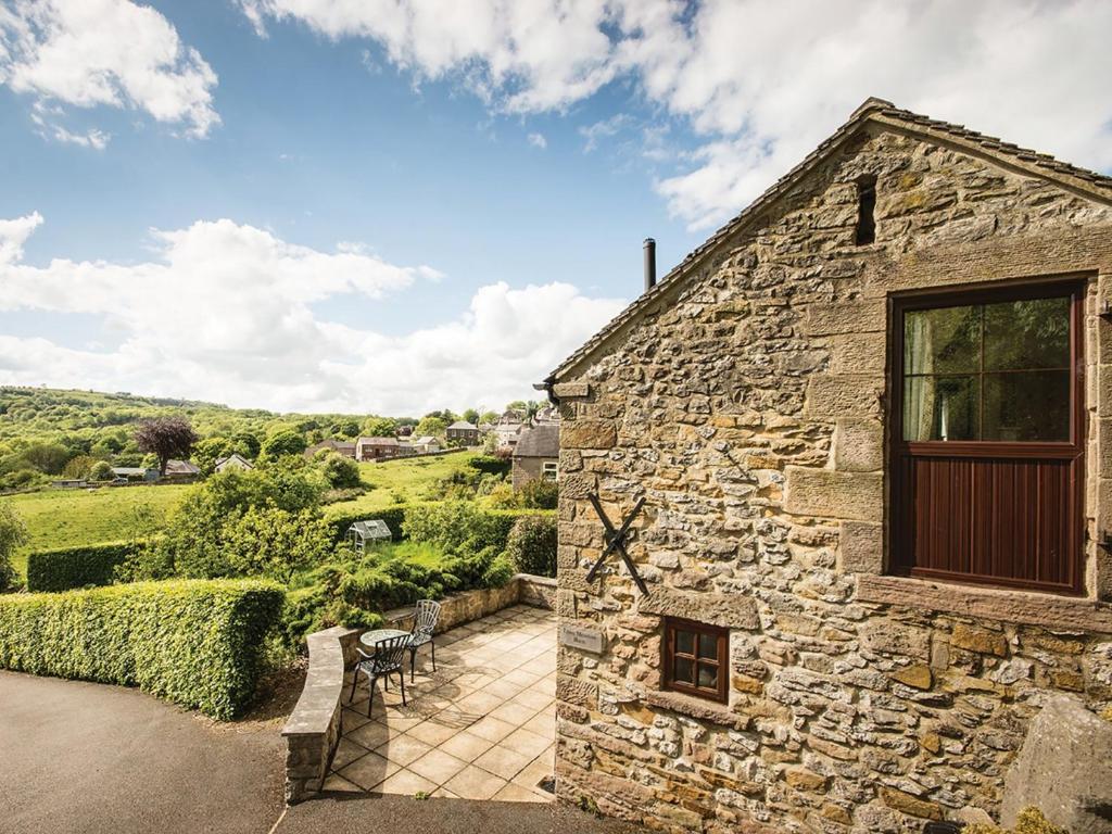 a stone house with a window and a patio at 1 Bed in Wirksworth PK925 in Wirksworth