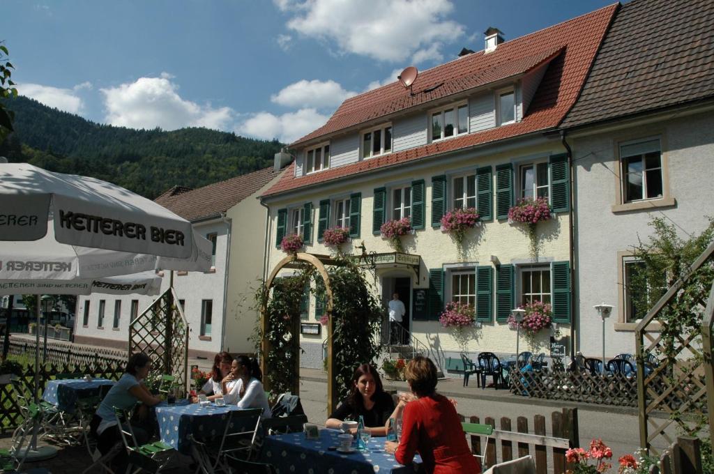 een groep mensen die aan tafels voor een gebouw zitten bij Gasthaus Schützen in Hornberg