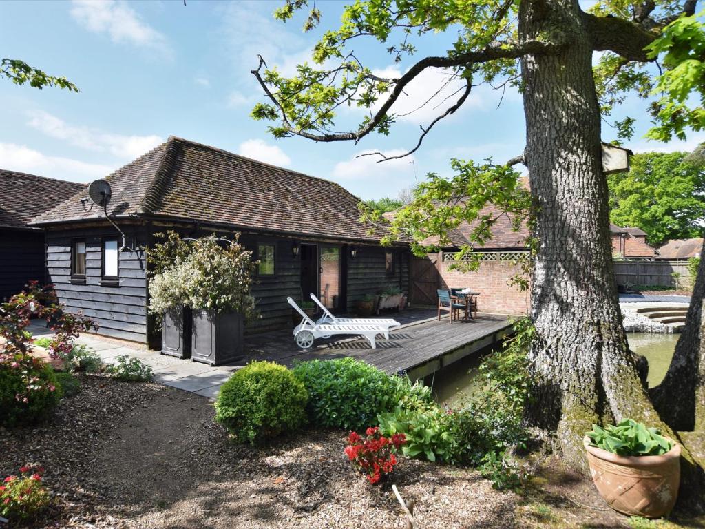 una casa con una terrazza in legno e un albero di 1 bed in Biddenden BT064 a Biddenden