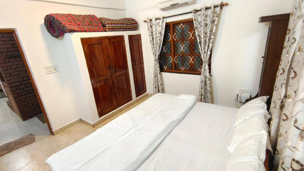 Villa Portuguese 2bhk house candolim goa في أنجونا: غرفة نوم صغيرة بها سرير ونافذة