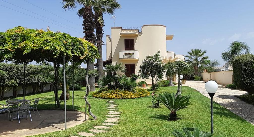 ein Haus mit Palmen und Rasen in der Unterkunft Villa Marino in Mazara del Vallo