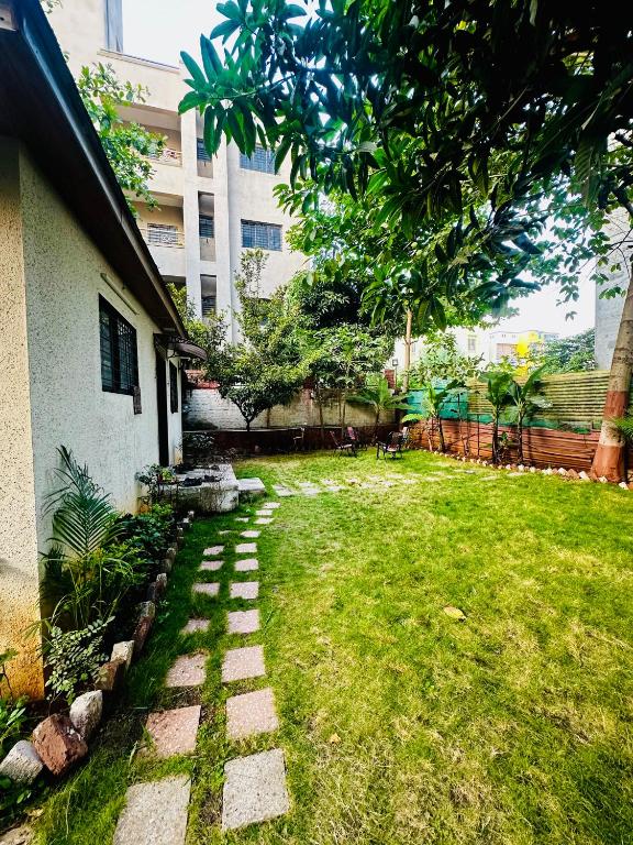 a yard with a brick walkway next to a building at Farmhouse in Pune city in Pune