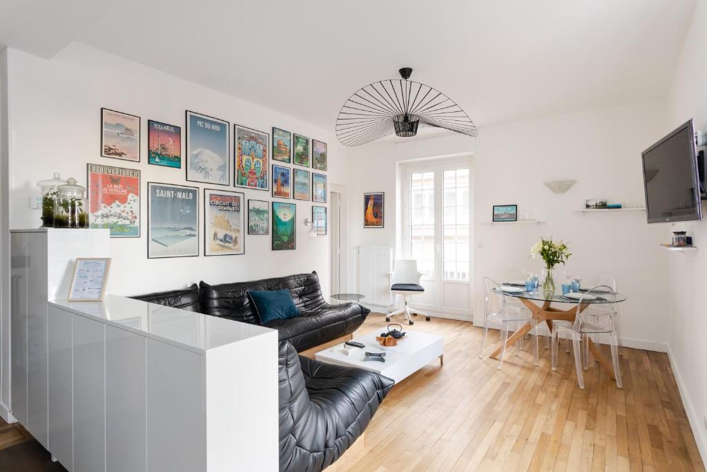 un salon avec un canapé en cuir noir et une table dans l'établissement Le Solent - Au cœur de l'intra-mutros, à Saint-Malo