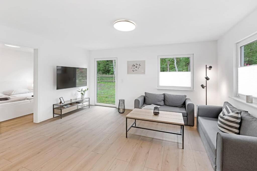 ein Wohnzimmer mit einem Sofa und einem Tisch in der Unterkunft Ferienhaus Dünenwald in Dierhagen