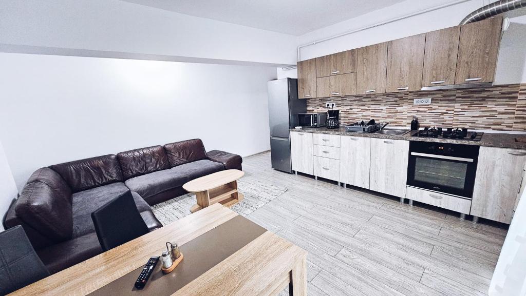 un soggiorno con divano e una cucina di Apartament Dem Radulescu 3 camere! a Râmnicu Vâlcea